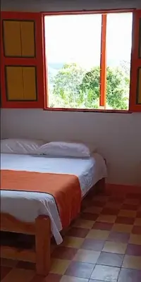 two beds in a room with two windows at Hospedaje Campestre El Rancho de Jero in Jardin