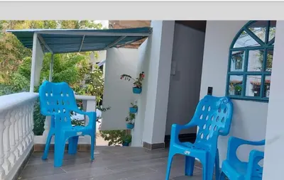 two blue chairs on the front porch of a house at Aldea Inmueble in Doradal
