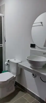 a bathroom with a toilet and a sink and a mirror at Aldea Inmueble in Doradal