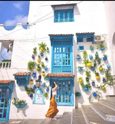 a woman dancing in front of a building with plants at Aldea Inmueble in Doradal