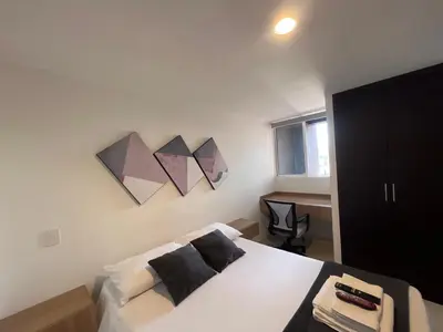a bedroom with a bed and two paintings on the wall at Hermoso y confort Apto en Medellín Cerca al Metro in Medellín