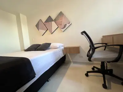 a bedroom with a bed and a desk and a chair at Hermoso y confort Apto en Medellín Cerca al Metro in Medellín
