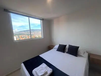 a bedroom with a bed with a large window at Hermoso y confort Apto en Medellín Cerca al Metro in Medellín