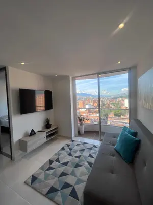a living room with a couch and a large window at Hermoso y confort Apto en Medellín Cerca al Metro in Medellín
