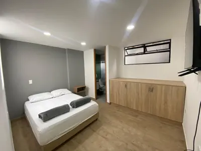 a bedroom with a bed and a television in it at Balcones de la pradera by Hope in Guatapé