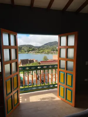 an open door to a balcony with a view of the water at Balcones de la pradera by Hope in Guatapé