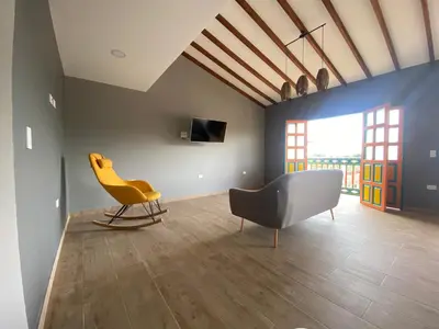 a living room with a yellow chair and a couch at Balcones de la pradera by Hope in Guatapé