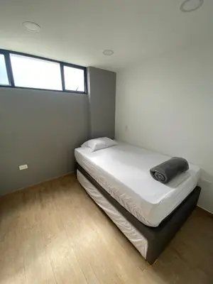 a bedroom with a bed in a room with windows at Balcones de la pradera by Hope in Guatapé