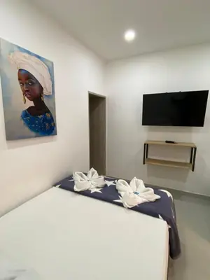 a bedroom with a bed with a painting of a woman at HOTEL BLUE GUATAPE in Guatapé