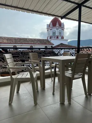 a table and chairs on a roof with a building at HOTEL BLUE GUATAPE in Guatapé
