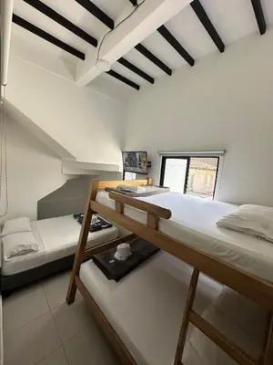 a room with two bunk beds and a window at HOTEL BLUE GUATAPE in Guatapé