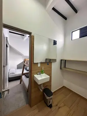 a bathroom with a sink and a bedroom at HOTEL BLUE GUATAPE in Guatapé