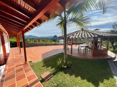 a patio with a table and a palm tree at Finca-hotel Montecarlo Guatape by Hope in Guatapé