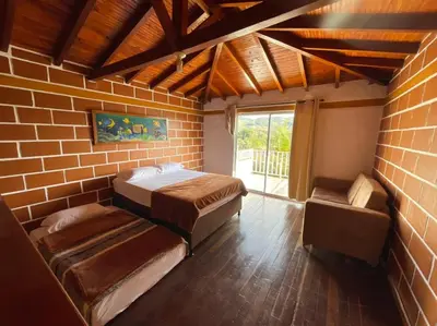 a bedroom with two beds and a brick wall at Finca-hotel Montecarlo Guatape by Hope in Guatapé