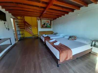 a bedroom with two beds and a wooden ceiling at Finca-hotel Montecarlo Guatape by Hope in Guatapé