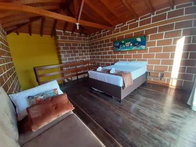 a bedroom with a bed and a brick wall at Finca-hotel Montecarlo Guatape by Hope in Guatapé