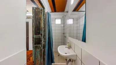 a bathroom with a sink and a mirror at Casa Los Naranjos Hostal in Medellín