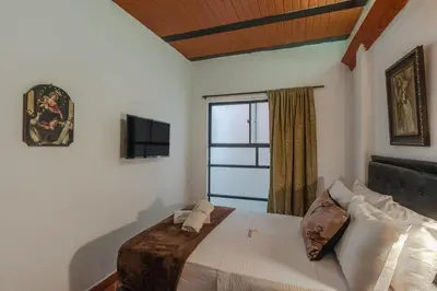 a bedroom with a large bed and a window at Casa Los Naranjos Hostal in Medellín