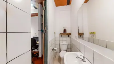 a white bathroom with a toilet and a sink at Casa Los Naranjos Hostal in Medellín