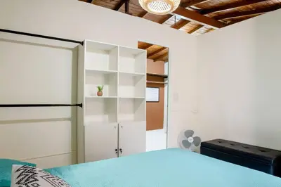 a bedroom with a bed and white cabinets and a door at Rústic-HOUSE Envigado in Envigado