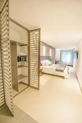 a bedroom with a bed and a mirror at Hotel Torre Poblado in Medellín