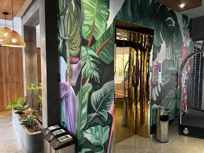a lobby with a mural of a plant at Hotel Torre Poblado in Medellín