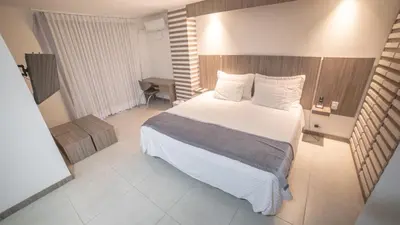 a bedroom with a large bed with white sheets and pillows at Hotel Torre Poblado in Medellín