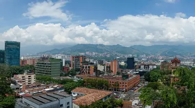 a city with buildings and mountains in the background at Hotel Torre Poblado in Medellín
