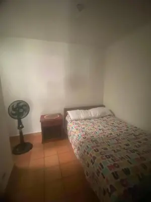 a small bedroom with a bed and a fan at CASA VACACIONAL CON PISCINAS EN SAN JERONIMO - CIUDADELA PREMIUm in Medellín