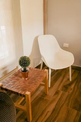 a white chair sitting next to a table and a bench at Finca hotel la fortuna in San Pedro