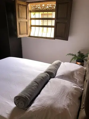 a bed with a blanket on it in a room with a window at Finca hotel la fortuna in San Pedro