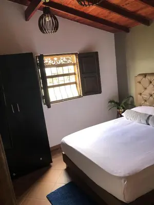 a bedroom with a large bed and a window at Finca hotel la fortuna in San Pedro