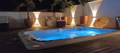 a hot tub sitting on a deck with potted plants at Hotel Primavera Santa Fe in Santa Fe de Antioquia