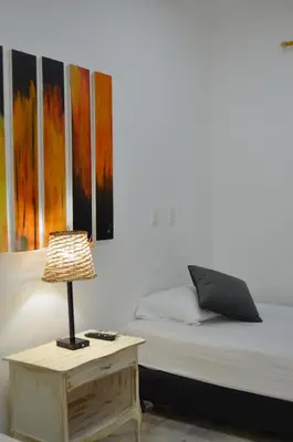 a bedroom with a bed and a table with a lamp at Hotel Primavera Santa Fe in Santa Fe de Antioquia