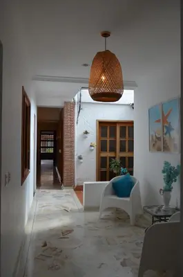 a living room with a couch and a pendant light at Hotel Primavera Santa Fe in Santa Fe de Antioquia