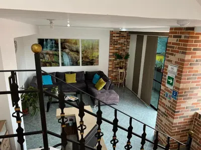 a living room with a couch and a brick wall at Hotel Primavera Santa Fe in Santa Fe de Antioquia