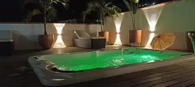 a hot tub with green water in a room with plants at Hotel Primavera Santa Fe in Santa Fe de Antioquia