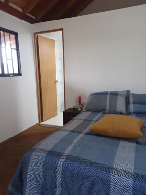 a bedroom with a blue bed with a yellow pillow at Glamping IKIGAI in Marinilla