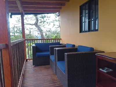a balcony with wicker chairs and a table at Glamping IKIGAI in Marinilla