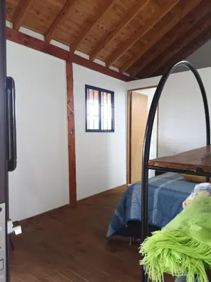 a room with a bed and a wooden floor at Glamping IKIGAI in Marinilla