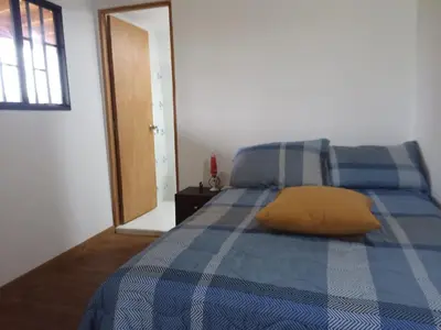 a blue bed with a yellow pillow on it at Glamping IKIGAI in Marinilla