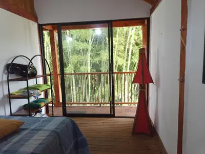 a bedroom with a bed and a sliding glass door at Glamping IKIGAI in Marinilla