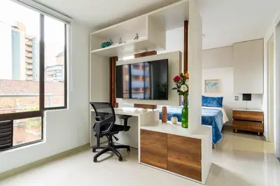 a bedroom with a desk and a bed and a mirror at Fabulous studio in the heart of Medellín in Medellín