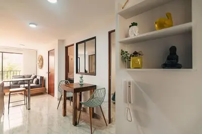 a living room with a table and chairs in a room at Hermoso y cómodo apartamento en El Poblado!!! in Medellín