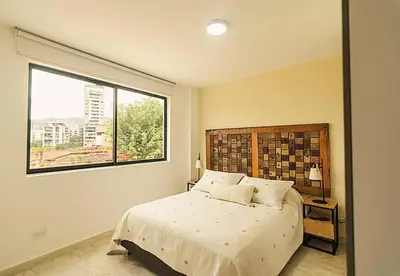 a bedroom with a large bed and a window at Hermoso y cómodo apartamento en El Poblado!!! in Medellín