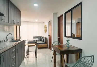 a kitchen with a table and chairs and a dining room at Hermoso y cómodo apartamento en El Poblado!!! in Medellín