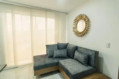 a couch in a living room with a mirror at Hermoso y cómodo apartamento en El Poblado!!! in Medellín