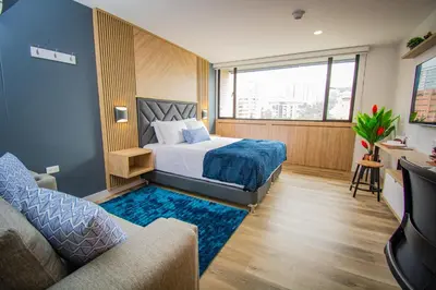 a hotel room with a bed and a couch at Unique Suite in El Poblado CoWork/ GYM / Fast WiFi in Medellín