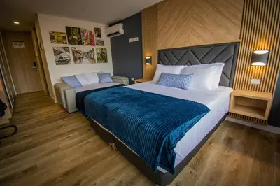 a bedroom with a large bed with a blue blanket at Unique Suite in El Poblado CoWork/ GYM / Fast WiFi in Medellín