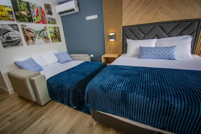 a hotel room with two beds and a chair at Unique Suite in El Poblado CoWork/ GYM / Fast WiFi in Medellín